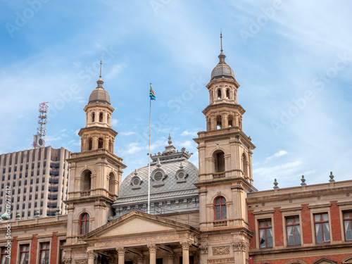 South African flag flies atop Palace of Justice, above columned balcony, between domed towers