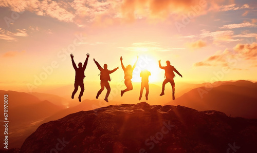 Silhouette of group of people jumping in the air in front of bright sunrise in mountain photo