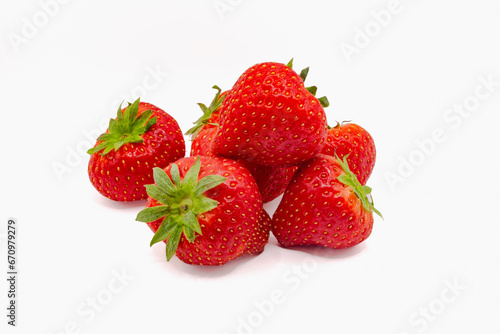 Fresh organic strawberries with green leaves isolated against white background