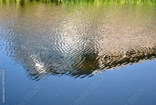 Reflections in Disturbed Waters of Industrial Canal on Sunny Day