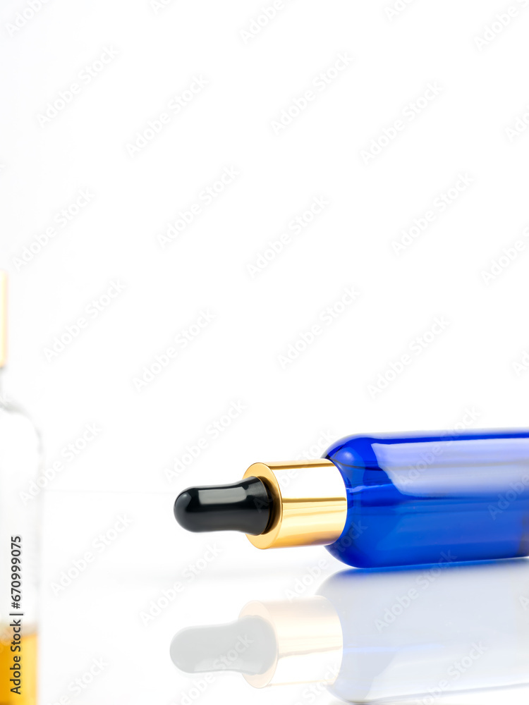 Blue glass cosmetic bottle with a dropper on a white background. Natural cosmetics concept, natural essential oil and skin care products. Copy space Blue glass cosmetic bottle with a dropper on a white background. Natural cosmetics concept, natural essential oil and skin care products. Copy space