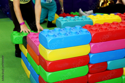 a child builds a wall of colorful toy building blocks in a children's center
