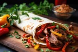 beef fajitas with onions and bell peppers in a tortilla
