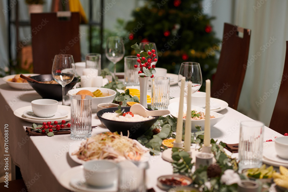 Table served for New Year celebration and decorated with candles and greenery Table served for New Year celebration and decorated with candles and greenery
