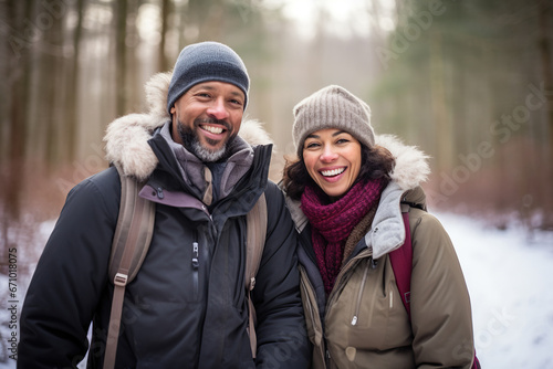 Middle age mixed race couple enjoying outdoors activity in winter woods