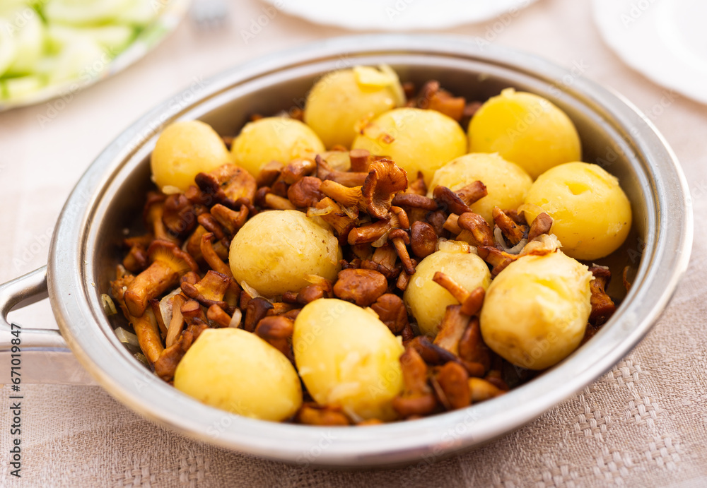 delicious fried chanterelle mushrooms with new potatoes in a frying pan delicious fried chanterelle mushrooms with new potatoes in a frying pan