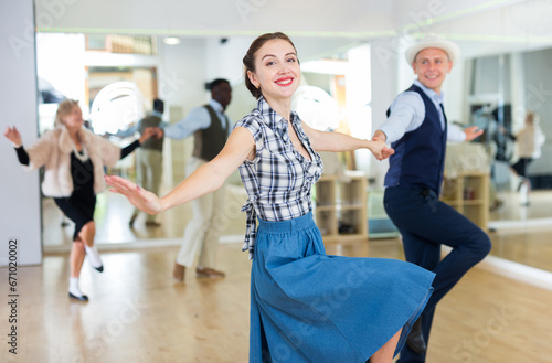 Cheerful female practicing lindy hop in pair with man