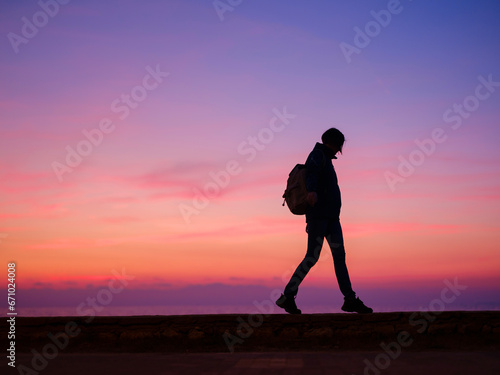 Woman tourist against colorful sunset sky. Travel  tourism concept. Active lifestyle.
