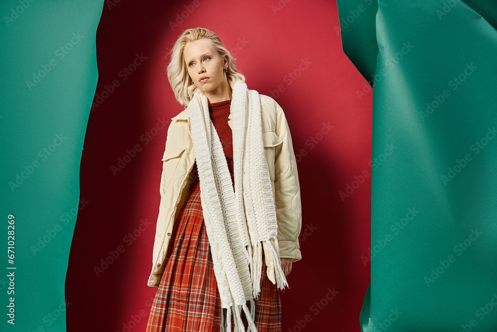 attractive woman in stylish winter outfit posing in white jacket on red with turquoise backdrop