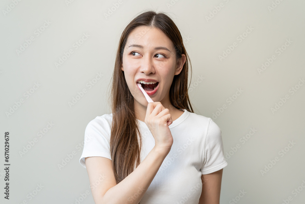 Close-up young woman brushing her teeth isolated on background Close-up young woman brushing her teeth isolated on background