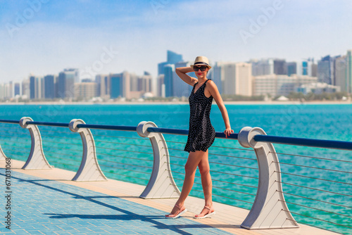 Obraz na płótnie Tourist woman in Abu Dhabi, UAE. Sea and downtown with skyscrapers w salonie