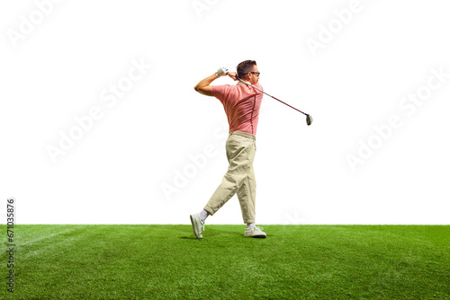 Rear view. Professional male golfer on green grass at golf club in summertime. Golfer taking shot at hole.