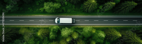 Top view of logistic transport truck on the road in the green forest. photo
