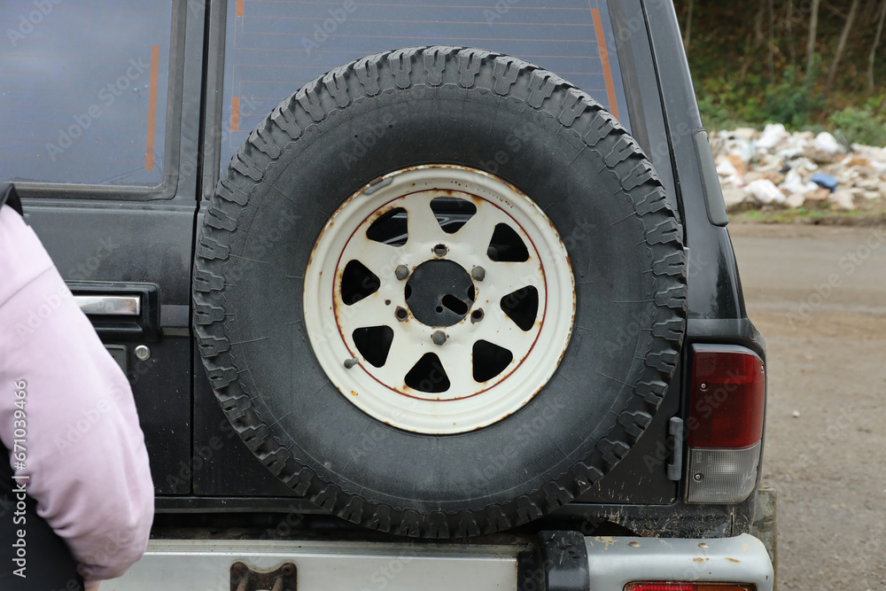 Wheel closeup in a countryside landscape with a mud road. Off-road 4x4 suv automobile with ditry body after drive in muddy road area Wheel closeup in a countryside landscape with a mud road. Off-road 4x4 suv automobile with ditry body after drive in muddy road area
