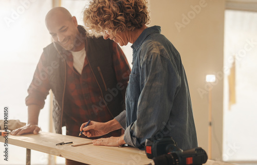 Homeowners discussing renovation project with tape measure and plank