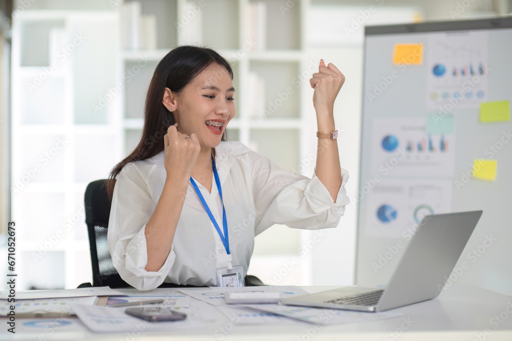 Asian businesswoman expresses joy With successful work on a white table in the office. Asian businesswoman expresses joy With successful work on a white table in the office.