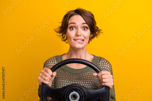 Photo portrait of pretty young girl hold steering wheel excited wear trendy knitwear khaki outfit isolated on yellow color background photo