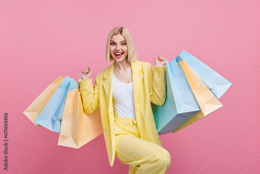 Portrait of overjoyed stunning lady hold mall bags enjoy special sale proposition isolated on pink color background