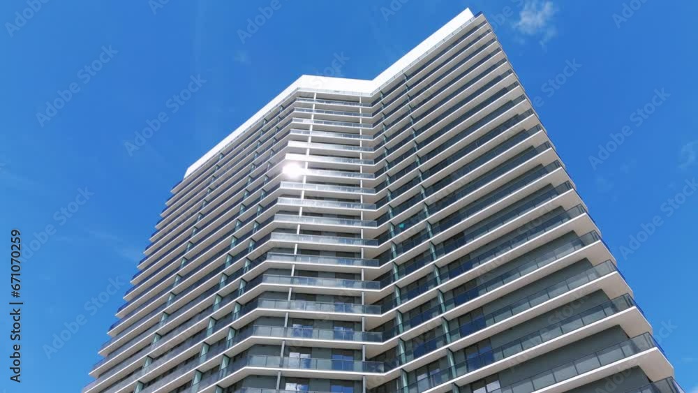 Low angle arc shot of impressive architectural structure against fair sky scenery. Super-tall building shaping urban silhouette of modern city Low angle arc shot of impressive architectural structure against fair sky scenery. Super-tall building shaping urban silhouette of modern city