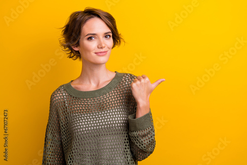 Photo of adorable cute girl wear trendy clothes recommend boutique store empty space isolated on yellow color background