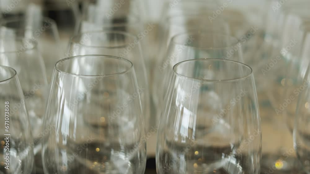 In the elegant setting of a fine dining restaurant, this shows rows of empty crystal-clear wine glasses, beautiful symbol of luxury and refinement, glassware await in shaping a memorable party. In the elegant setting of a fine dining restaurant, this shows rows of empty crystal-clear wine glasses, beautiful symbol of luxury and refinement, glassware await in shaping a memorable party.