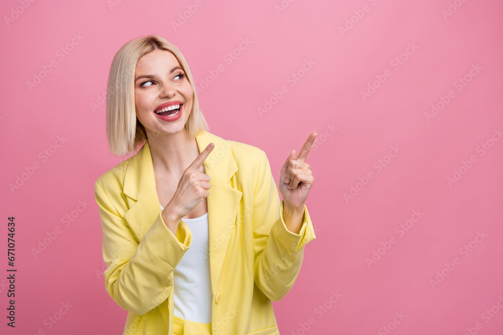 Photo of sweet excited lady wear yellow jacket suit looking showing two fingers empty space isolated pink color background Photo of sweet excited lady wear yellow jacket suit looking showing two fingers empty space isolated pink color background