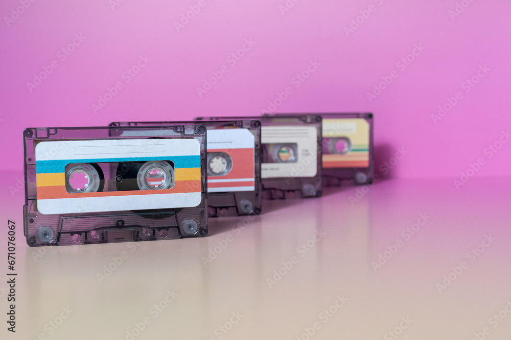 Row of audio cassette on fuchsia background.