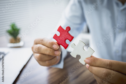 person hand connecting jigsaw puzzle, Business solutions, target, success, goals and strategy concepts,  teamwork idea. © Tinnakorn