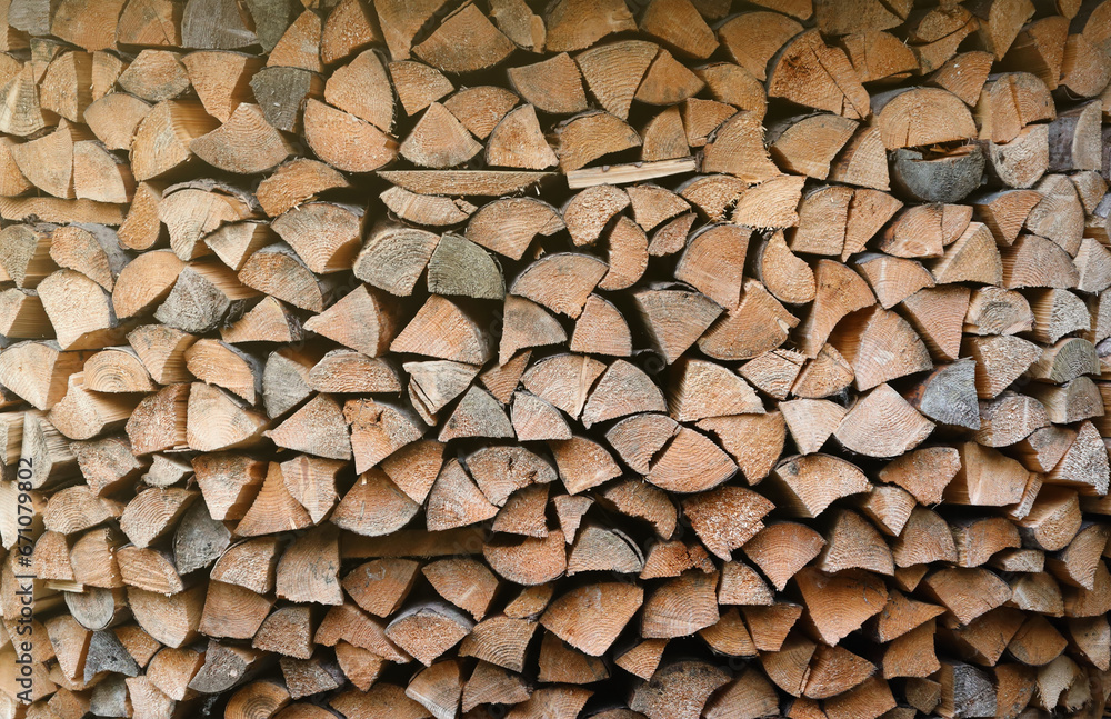 Firewood stacked near the wooden wall of old hut. Many chopped logs of firewood close up Firewood stacked near the wooden wall of old hut. Many chopped logs of firewood close up