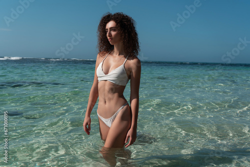 Sexy athletic girl posing against the background of the ocean