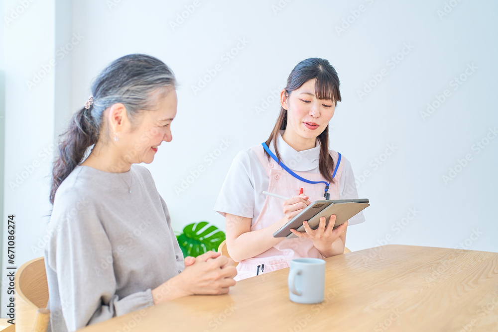 会話するシニア女性とエプロン姿の若い女性 会話するシニア女性とエプロン姿の若い女性