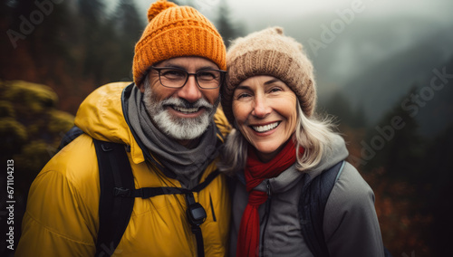 smiling mature adult couple in the mountains with backpacks on