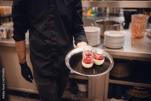Fototapeta Naklejka Na Ścianę i Meble -  Kellner holt Dessert aus Großküche