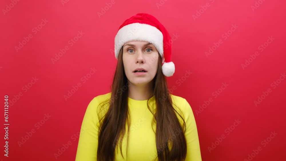 Merry shocked amazed young woman 25s wear yellow sweater and Santa Claus hat cover mouth with hands, posing isolated over pastel red studio background. Happy New Year 2024 celebration holiday concept Merry shocked amazed young woman 25s wear yellow sweater and Santa Claus hat cover mouth with hands, posing isolated over pastel red studio background. Happy New Year 2024 celebration holiday concept