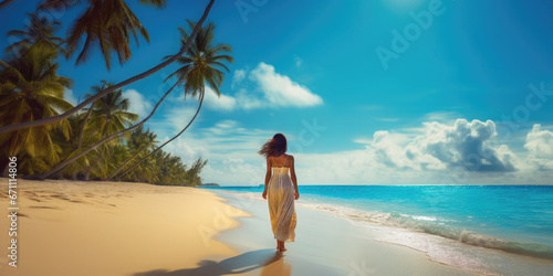 back-view of woman walking on the caribbean beach photo