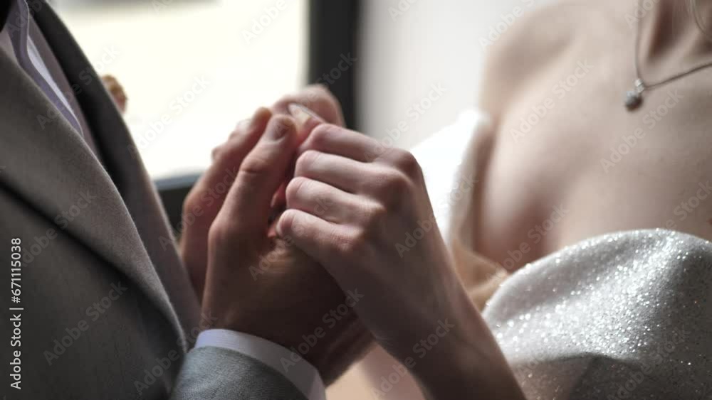 groom tenderly holds the bride's hands. Close-up of the bride and groom holding hands, wedding couple groom tenderly holds the bride's hands. Close-up of the bride and groom holding hands, wedding couple