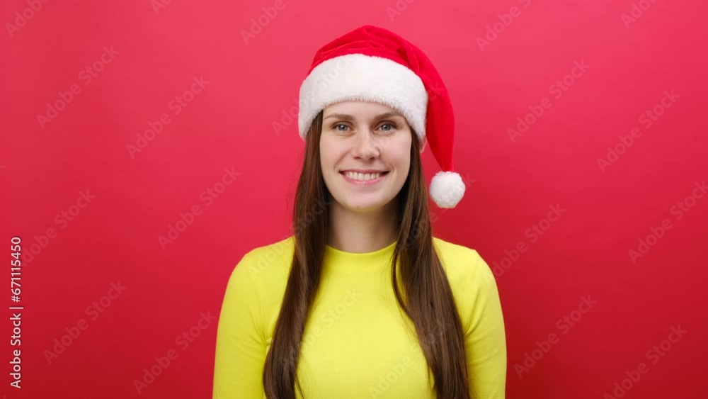 Merry young woman 25s wear warm yellow sweater and Santa Claus hat say hush be quiet with finger on lips shhh gesture, posing isolated over pastel red background. Happy New Year 2024 holiday concept Merry young woman 25s wear warm yellow sweater and Santa Claus hat say hush be quiet with finger on lips shhh gesture, posing isolated over pastel red background. Happy New Year 2024 holiday concept