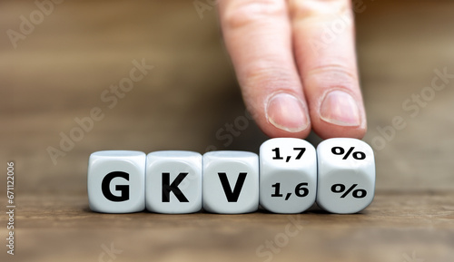 Hand dreht Würfel und ändert des Ausdruck 'GKV 1,6 %' in 'GKV 1,7%'. Symbol für die Anhebung des Krankenkassen-Zusatzbeitrag um 0,1 Prozent in Deutschland.  photo