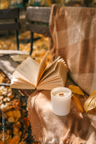 Candle and open book in nature, autumn concept