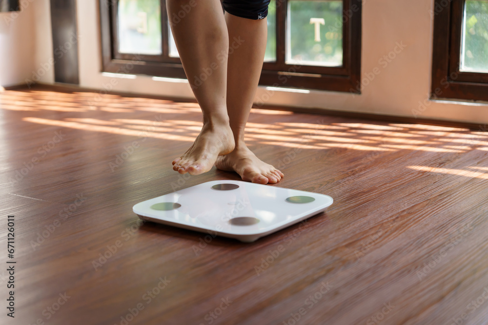 Fat diet and scale feet standing on electronic scales for weight control. Measurement instrument in kilogram for a diet control - obrazy, fototapety, plakaty 