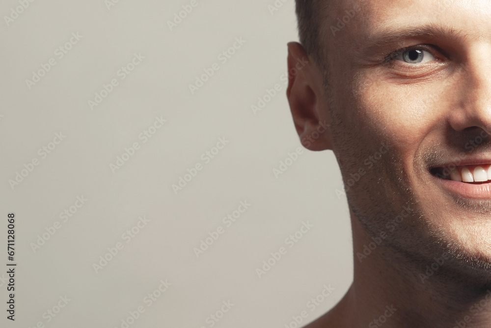 Fototapeta premium Male beauty concept. Portrait of handsome 30-year-old man with blue eyes posing over gray background. Close up. Classic style. Shiny white smile. Headshot. Studio shot