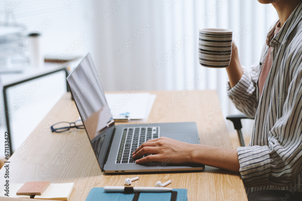 Fototapeta premium Freelancer drinking morning coffee and checking e-mails from client on laptop