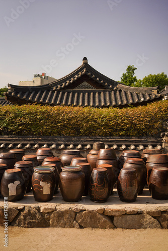 Traditional korean kimchi jars onggi with the house in the background