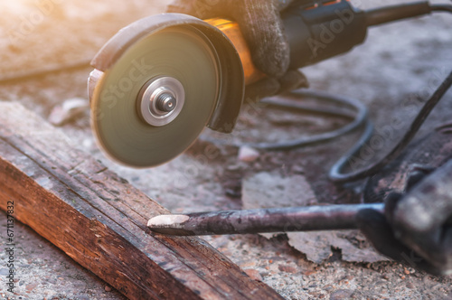 A worker sharpens scrap steel using an angle grinder. Restoring a dull tool at the workplace. Close up.