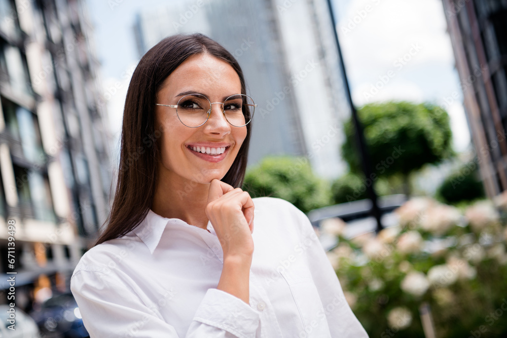 Photo of intelligent happy lady sales manager dressed white shirt eyewear smiling arm hand chin outdoors urban town street Photo of intelligent happy lady sales manager dressed white shirt eyewear smiling arm hand chin outdoors urban town street