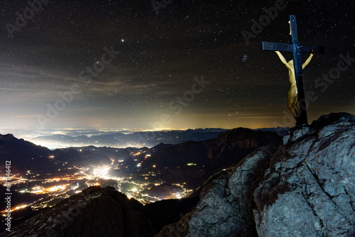 Blick auf Berchtesgaden am Watzmann Hocheck am Gipfel mit Gipfelkreuz in der Nacht bei sternenklarem Himmel