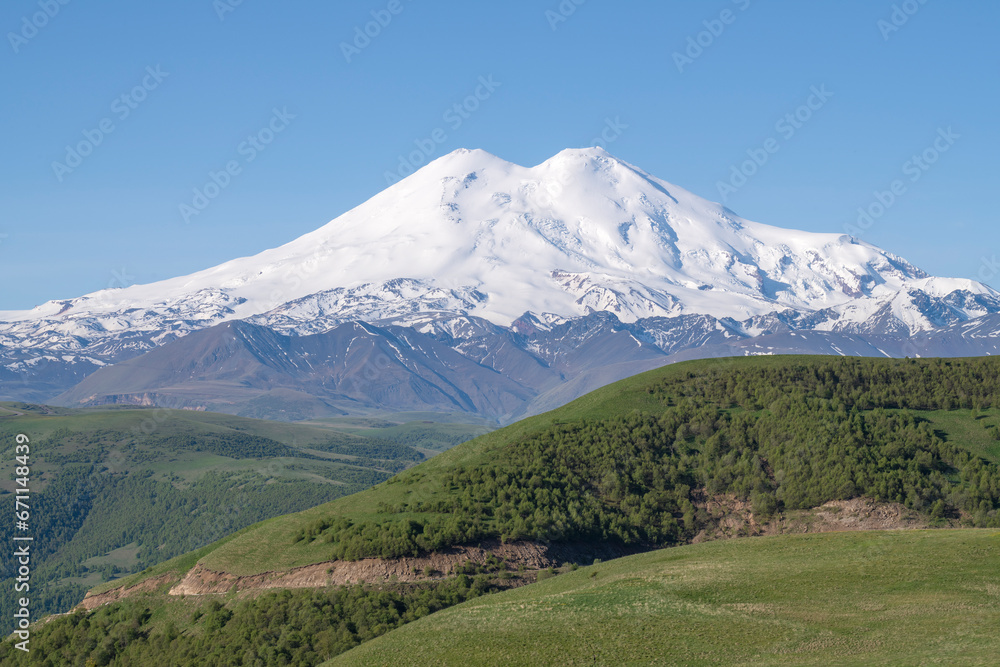 Elbrus Mount in the morning June landscape. Kabardino-Balkaria, Russia Elbrus Mount in the morning June landscape. Kabardino-Balkaria, Russia