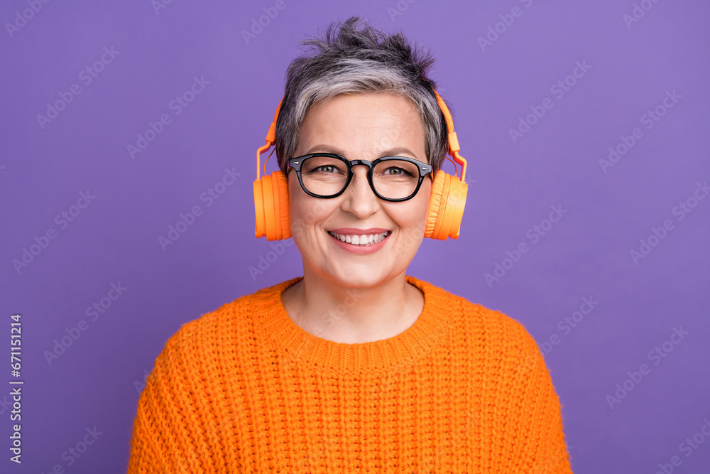 Portrait of good mood person with gray hairstyle wear knit jumper listen playlist in headphones isolated on violet color background
