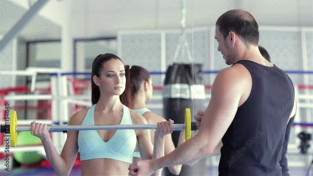 Fitness instructor shows a young girl athlete what muscle group work Fitness instructor shows a young girl athlete what muscle group work