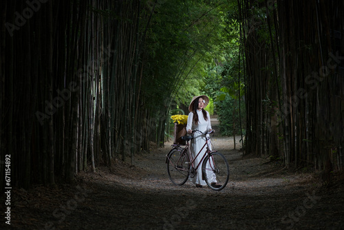 person riding a bicycle. Portrait beautiful woman with Vietnam culture traditional dress, Ao dai and riding bicycle in fields.